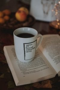 mug with words sitting on a book on a table. 