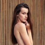 woman posing nude with a wooden background